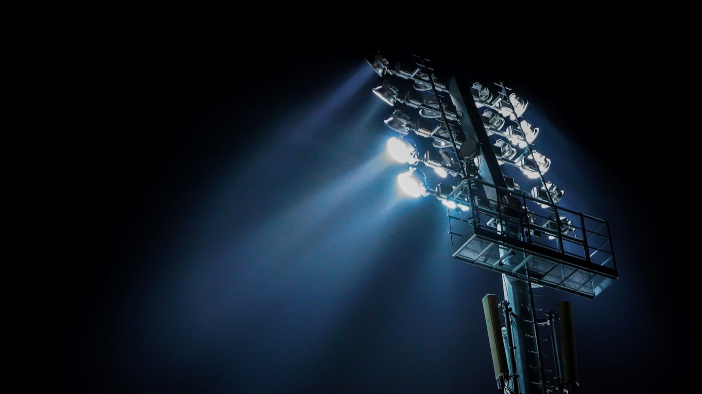 Flutlichtmast über einem Stadion bei Nacht