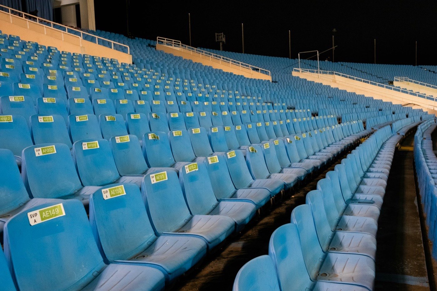 Leere Sitzreihen im Stadion bei Nacht